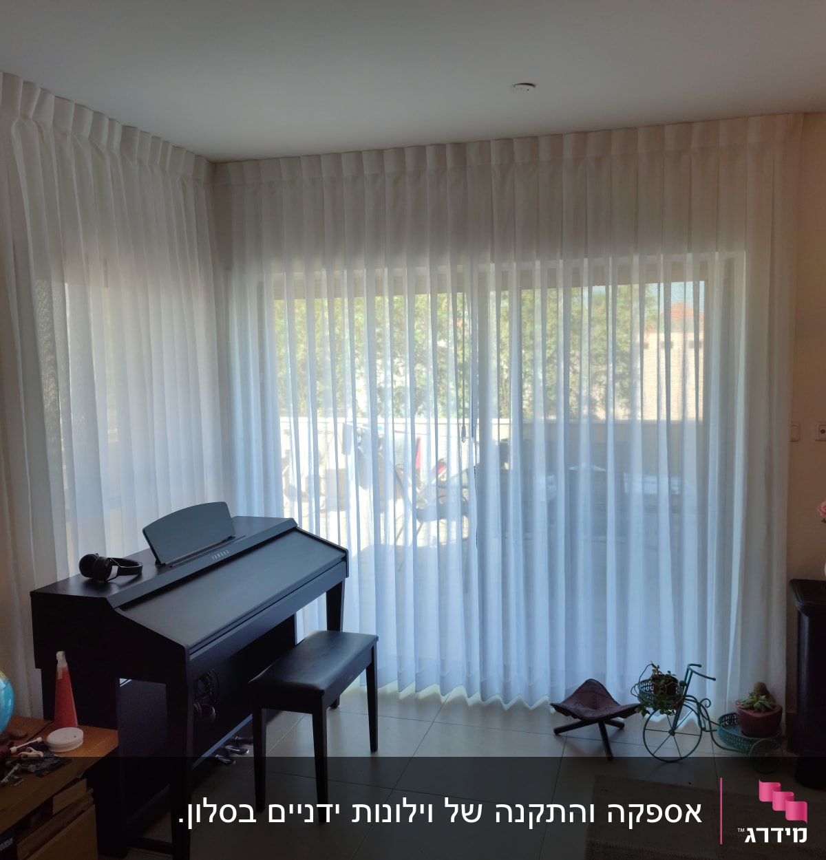 וילון לבן שקוף תלוי על חלון גדול בסלון